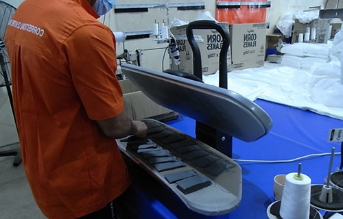 Ironing curtain tabs at Woodford Correctional Centre, industrial workshop.