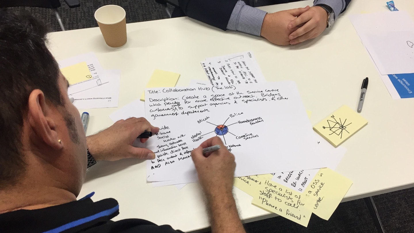 Staff member using pen and paper to draw a design concept.